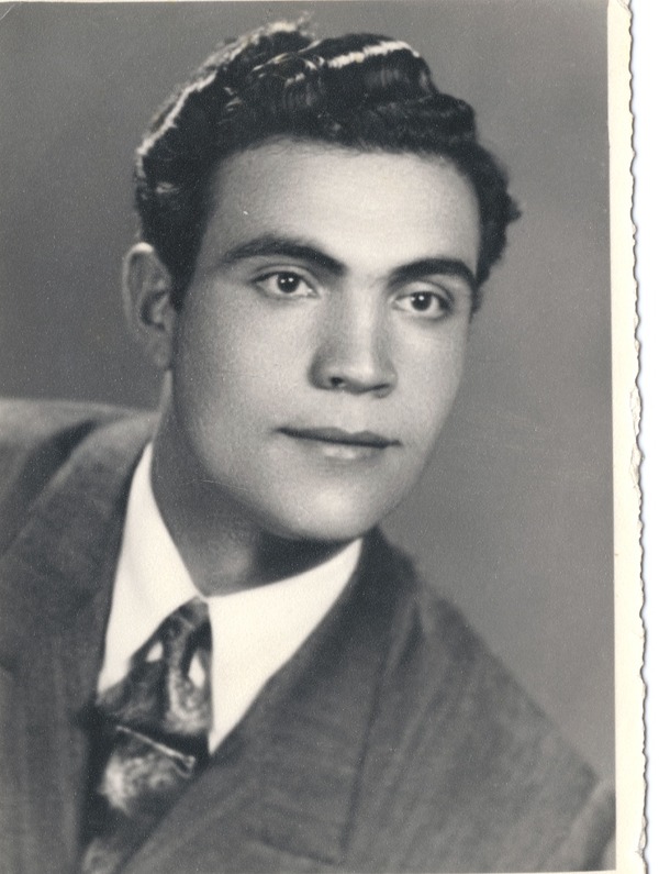 Original photograph of a man in a suit, with its white paper edge, fading and scratches.